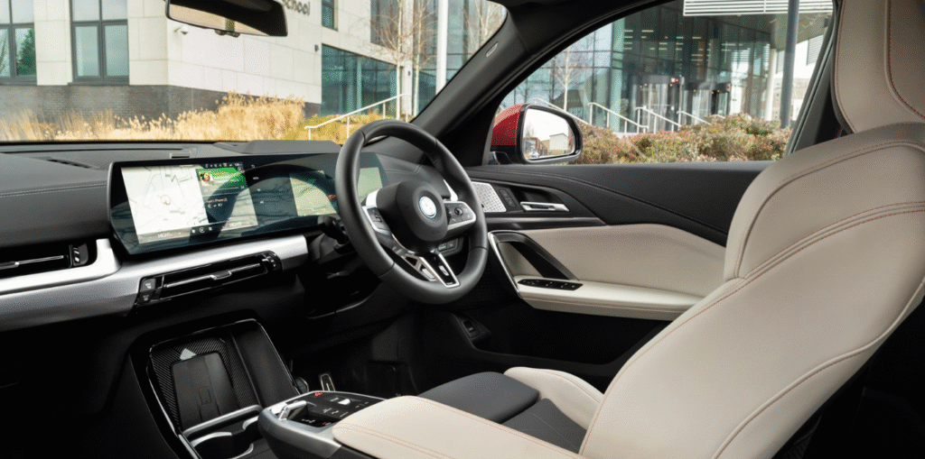 Interior of BMW iX2 showing curved display and OS9 infotainment